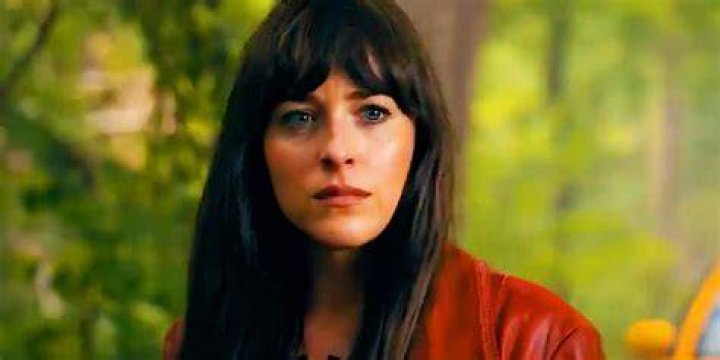 Cassandra Webb (Dakota Johnson) in her paramedic uniform stands by an ambulance in Madame Web