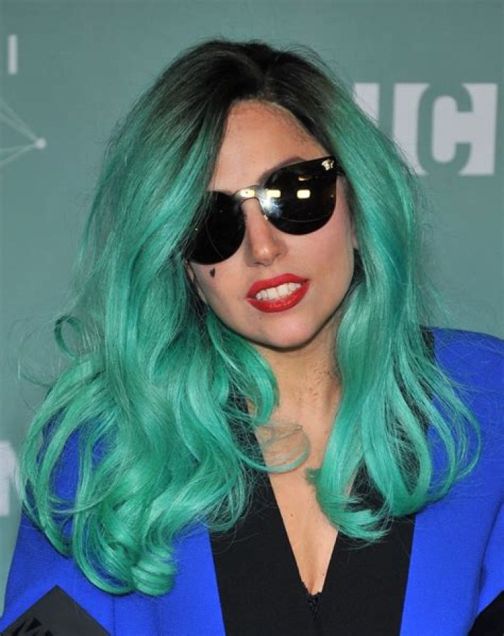 Lady Gaga in a teal colored dress on stage